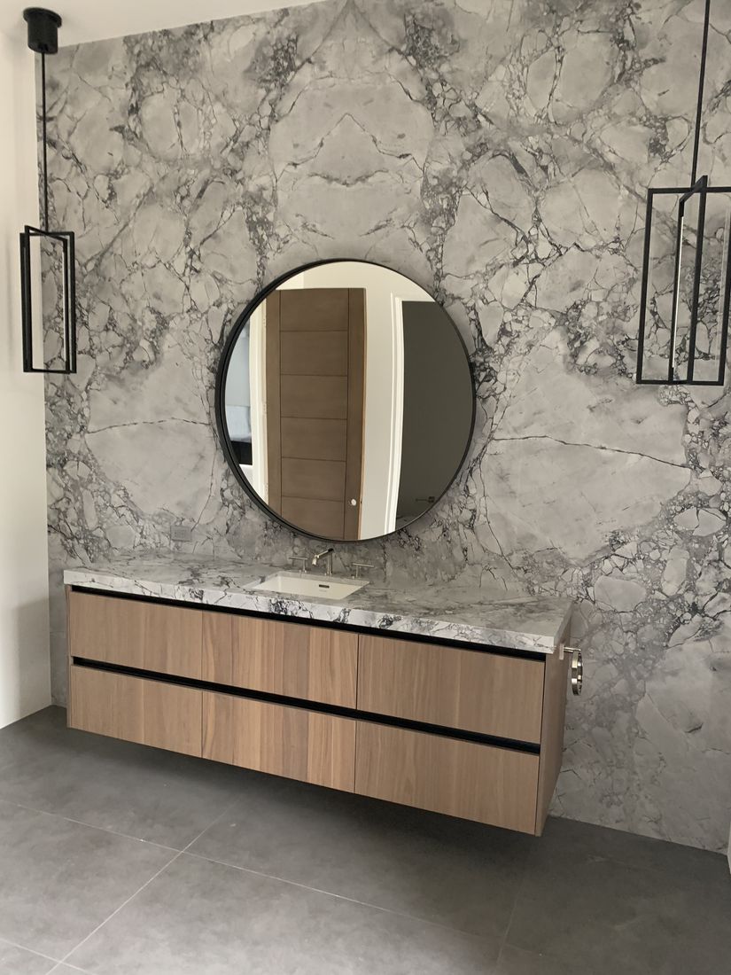 Custom bathroom with a dramatic marble feature wall and a floating wood vanity, San Diego