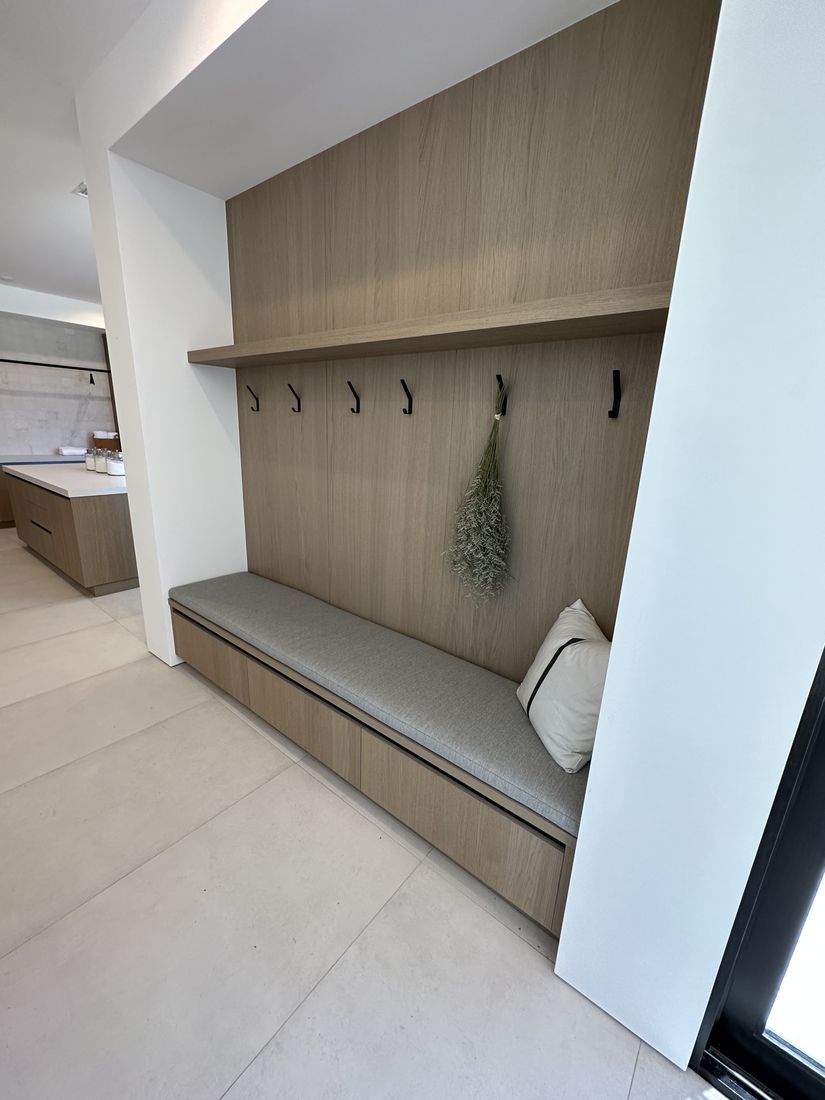 Custom mudroom with a built-in bench, cushioned seat, and coat hooks, San Diego